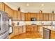 Spacious kitchen with wood cabinets, granite countertops, stainless steel appliances, and hardwood flooring at 501 Young Cir, Castle Rock, CO 80104