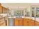 Bright, open kitchen with island, wood cabinets, stone counters, and eat-in dining with mountain views at 501 Young Cir, Castle Rock, CO 80104