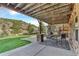 Covered outdoor patio with stone columns, dining set, and serene views of the landscape at 501 Young Cir, Castle Rock, CO 80104