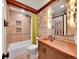 Well-lit bathroom showcasing textured stone wall, copper sink, and tiled shower and bathtub at 24354 Eagle Cliff Trl, Conifer, CO 80433
