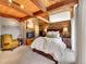 Bedroom featuring a fireplace, exposed beams, and large bed with view of the room at 24354 Eagle Cliff Trl, Conifer, CO 80433