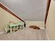 Attic room with exposed beams, carpet and natural light offers a simple, comfortable play area for children at 24354 Eagle Cliff Trl, Conifer, CO 80433