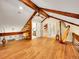 An open room featuring exposed beams, hardwood floors, and natural light, creating a flexible living space at 24354 Eagle Cliff Trl, Conifer, CO 80433