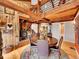 Open concept dining area with wood beams, wood burning stove and views of the upper landing at 24354 Eagle Cliff Trl, Conifer, CO 80433