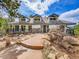 Inviting exterior features a stone accented facade, blue trim, and a stepstone path to the front door at 24354 Eagle Cliff Trl, Conifer, CO 80433