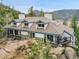 Aerial view of a charming mountain home with a stone foundation, dormer windows, and inviting balconies at 24354 Eagle Cliff Trl, Conifer, CO 80433