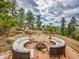 Enjoy outdoor living with a custom stone patio featuring comfortable seating and a fire pit with mountain views at 24354 Eagle Cliff Trl, Conifer, CO 80433