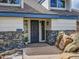 Close up of front door entrance with stacked stone accents and views of the surrounding rock landscape at 24354 Eagle Cliff Trl, Conifer, CO 80433