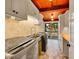Bright laundry room with modern appliances, ample counter space, storage cabinets and unique exposed ceiling beams at 24354 Eagle Cliff Trl, Conifer, CO 80433