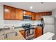 Bright kitchen featuring stainless steel appliances, granite countertops, and wooden cabinets at 100 Park W Ave # 304, Denver, CO 80205