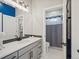 This bright bathroom features a blue accent wall and includes a door that leads to a tiled shower at 1291 Fountain Ln, Erie, CO 80516