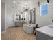 Spa-like bathroom with modern tub, unique tile flooring, and designer lighting fixtures at 1291 Fountain Ln, Erie, CO 80516