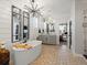 Luxurious bathroom with double vanity, soaking tub, accent mirrors, and modern lighting at 1291 Fountain Ln, Erie, CO 80516
