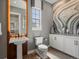 This modern bathroom features a pedestal sink, cabinet, elegant mirror, stylish window, and artwork at 1291 Fountain Ln, Erie, CO 80516