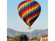 Image shows a hot air balloon rising in the distance, with mountains in the background at 1291 Fountain Ln, Erie, CO 80516