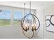 A chandelier hangs in front of a bank of windows, offering scenic views from the staircase landing at 1291 Fountain Ln, Erie, CO 80516