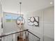 A staircase and landing with white wood paneling is illuminated by a chandelier and natural light at 1291 Fountain Ln, Erie, CO 80516