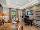 This home office boasts a wood accent wall, modern lighting, stylish furniture, and a large window at 1291 Fountain Ln, Erie, CO 80516