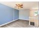 Spacious upstairs bedroom with blue accent wall, gray flooring, and ceiling fan at 13265 Raritan St, Denver, CO 80234