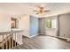 Well-lit upstairs bedroom with ceiling fan, large window, and gray flooring at 13265 Raritan St, Denver, CO 80234