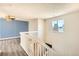 Bright upstairs hallway featuring modern light fixture and gray wood-look floors at 13265 Raritan St, Denver, CO 80234
