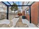 Cozy backyard patio area with brick flooring, pergola and privacy fence, perfect for outdoor relaxation at 9886 Appletree Pl, Thornton, CO 80260