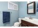 Bright bathroom featuring blue walls, sleek vanity, modern mirror, and a plush blue towel at 9886 Appletree Pl, Thornton, CO 80260