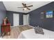 Bedroom showcasing modern gray walls, ceiling fan, wood-look flooring, and a minimalist aesthetic at 9886 Appletree Pl, Thornton, CO 80260