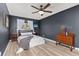 Stylish bedroom with contemporary dark gray wall paint, ceiling fan, and vinyl plank flooring at 9886 Appletree Pl, Thornton, CO 80260