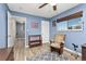 Blue bedroom featuring a cozy reading nook with swivel chair, complemented by wood-look vinyl plank flooring at 9886 Appletree Pl, Thornton, CO 80260