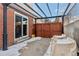 Back patio with covered pergola, brick siding, fenced yard, and space for outdoor seating at 9886 Appletree Pl, Thornton, CO 80260