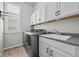 Bright laundry room featuring a washer, dryer, utility sink and counter space with white cabinets for storage at 3429 Goodyear St, Castle Rock, CO 80109