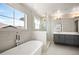 Spa-like bathroom with soaking tub, glass enclosed shower, dual sink vanity and a window at 2136 S Juniper St, Lakewood, CO 80228
