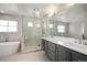 Bathroom featuring a soaking tub, glass-enclosed shower, and modern dual vanity at 2136 S Juniper St, Lakewood, CO 80228