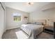 Bright bedroom with a large window, soft carpet, and comfortable bed with a decorative bedside table at 2136 S Juniper St, Lakewood, CO 80228