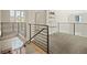 Hallway with metal railing and carpet flooring with a view of the chandelier in the foyer at 2136 S Juniper St, Lakewood, CO 80228