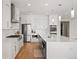Bright kitchen boasts stainless steel appliances, white cabinetry, and quartz countertops at 2136 S Juniper St, Lakewood, CO 80228