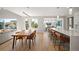 Open-concept living space featuring hardwood floors, a kitchen island, and access to a balcony at 2136 S Juniper St, Lakewood, CO 80228
