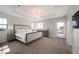 Bright main bedroom with tray ceiling, large bed, and access to a private balcony at 2136 S Juniper St, Lakewood, CO 80228