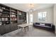Home office featuring built-in bookshelves, a stylish light fixture, and a comfortable seating area at 2136 S Juniper St, Lakewood, CO 80228