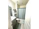 Clean bathroom with a single sink vanity, tiled floor, and a shower with a patterned shower curtain at 7435 E 159Th Pl, Thornton, CO 80602