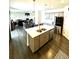 Open kitchen and living space with an eat-in island and stainless steel appliances at 7435 E 159Th Pl, Thornton, CO 80602
