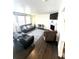 Open concept living room featuring dark hardwood floors, a fireplace, and plenty of seating at 7435 E 159Th Pl, Thornton, CO 80602