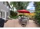 Beautiful backyard with lush landscaping, patio, outdoor seating, and a red umbrella for shade at 9170 Fox Fire Dr, Highlands Ranch, CO 80129