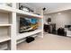 Spacious basement with built-in shelving, bar area, comfortable seating and a mounted flat screen TV at 9170 Fox Fire Dr, Highlands Ranch, CO 80129