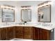 Modern bathroom featuring marble countertops, wood cabinets and triple mirrors at 9170 Fox Fire Dr, Highlands Ranch, CO 80129