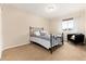 Bright bedroom featuring a wrought iron bed frame, sleek black chair, and neutral decor at 9170 Fox Fire Dr, Highlands Ranch, CO 80129