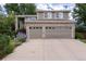 Two-story home features a two-car garage, brick accents, manicured front yard with mature trees and beautiful landscaping at 9170 Fox Fire Dr, Highlands Ranch, CO 80129