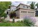 Well-maintained home with a two-car garage, beautiful landscaping, and a welcoming walkway leading to the front door at 9170 Fox Fire Dr, Highlands Ranch, CO 80129