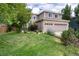 This two-story home has a lush front yard with established trees and a well-maintained green lawn at 9170 Fox Fire Dr, Highlands Ranch, CO 80129